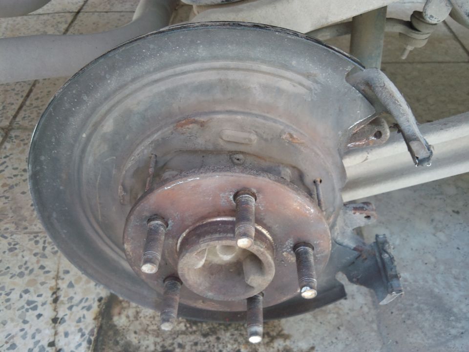 Rear brake rotor and hub assembly of a 1998 Ford Crown Victoria, showing rust and wear