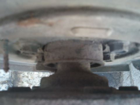 1998 Ford Crown Victoria - This image shows a close-up view of a vehicle's brake caliper mount, with visible rust and wear on the metal parts.
