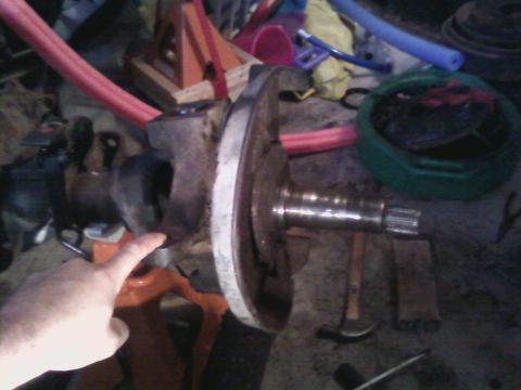 1994 Ford Bronco - A vehicle's axle and hub assembly is shown with various tools and parts scattered around the workspace.