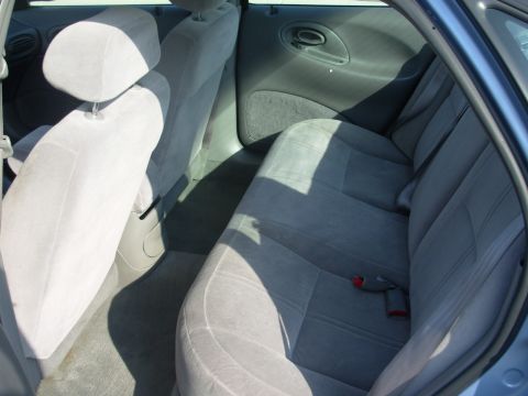 1997 Ford Taurus - The rear seating area of a car, showing the bench seat, headrests, and door panel.