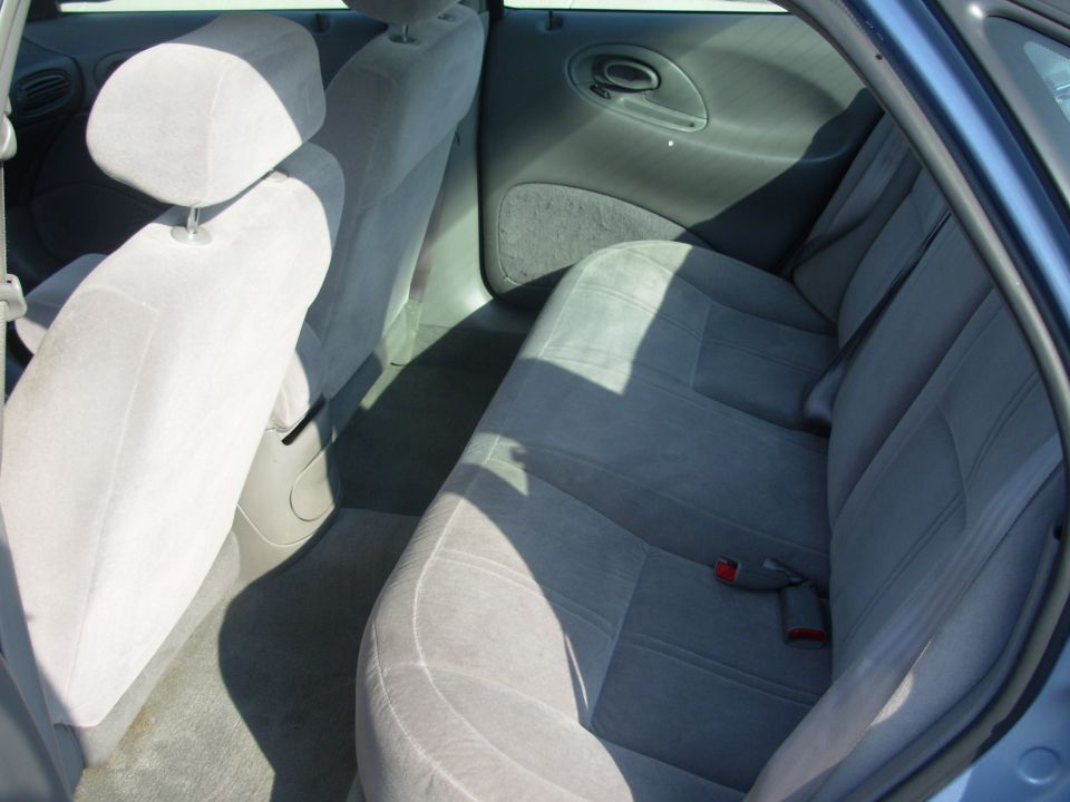 Back seat and door panel of a car. Light gray cloth seats and dark gray interior trim