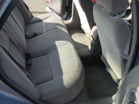 1997 Ford Taurus - The back seat and floor of a car are shown, with gray cloth upholstery and seatbelts.