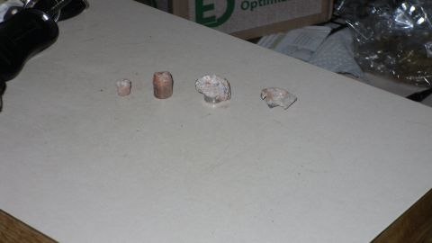 2000 Chevrolet Tahoe - A flashlight is positioned above a collection of four small rocks laid out on a flat surface.