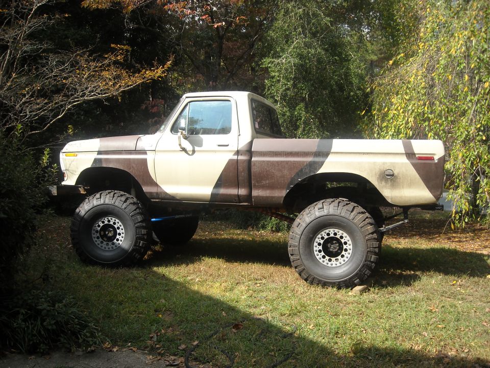 Lifted pickup truck with camouflage paint scheme, seen from the side