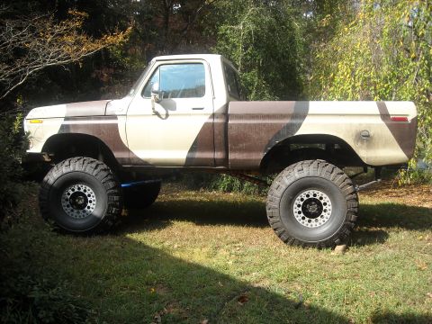 1979 Ford F-150 - This lifted 1979 Ford F-150 pickup truck features a distinctive camouflage paint scheme and oversized off-road tires.