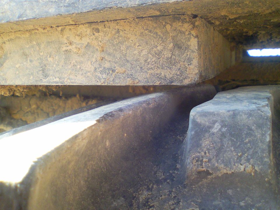 Close-up of a tire tread and suspension parts, showing dirt and wear