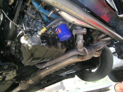 1995 Ford Probe - Close-up of the engine's oil pan and exhaust system, with a blue oil filter visible.