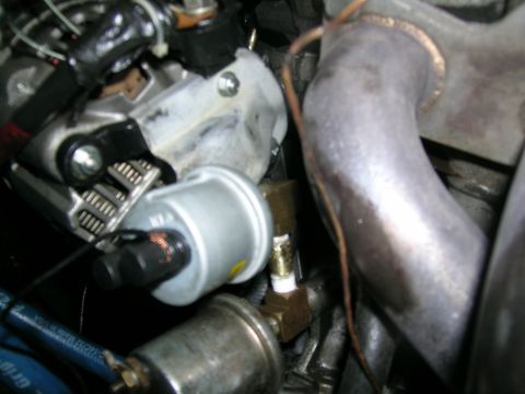 1995 Ford Probe - A close-up view of engine components, including a pressure gauge and exhaust piping.