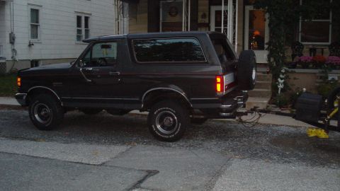 1988 Ford Bronco - This dark gray SUV, identified as a 1987 model, is seen from the rear with a spare tire mounted externally.