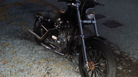 1988 Ford Bronco - This black motorcycle has chrome accents and is parked on a gravel surface.
