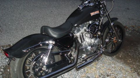 1988 Ford Bronco - A black Harley-Davidson motorcycle is shown from the side, parked on a gravel surface.