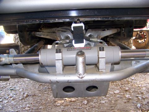 1992 Jeep YJ - Close-up of a power steering cylinder and linkage assembly on a vehicle's undercarriage.
