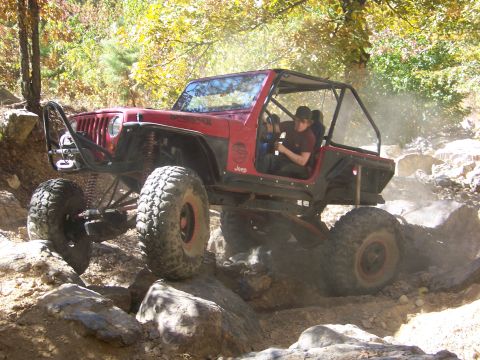 1992 Jeep YJ - This modified Jeep YJ navigates a rocky trail with a driver behind the wheel.