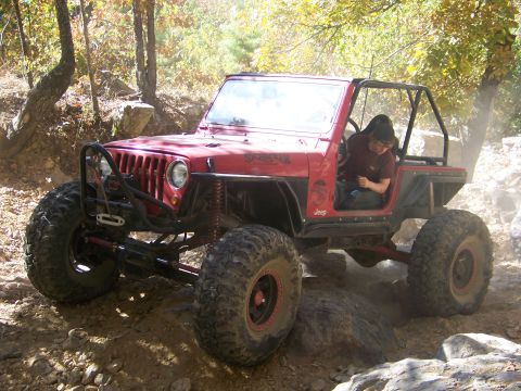1992 Jeep YJ - This modified 1992 Jeep YJ navigates a challenging off-road course with large tires and a roll cage.