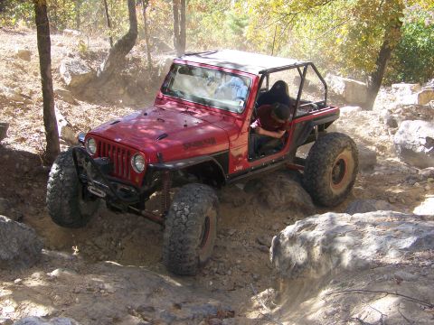 1992 Jeep YJ - This 1992 Jeep YJ is shown tackling a challenging off-road course with large rocks.