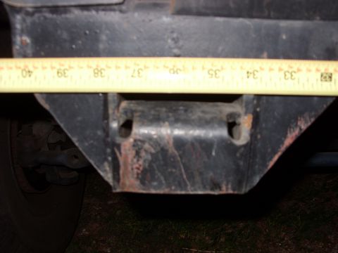 1988 Ford Bronco - A close-up view of a vehicle's frame component, with a measuring tape indicating dimensions.