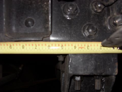 1988 Ford Bronco - A yellow measuring tape is placed against a black metal vehicle frame, indicating a measurement.