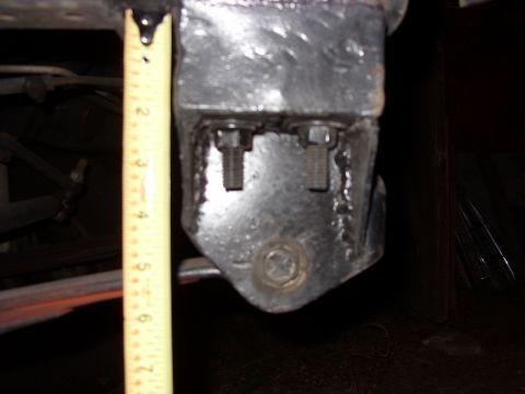 1988 Ford Bronco - Close-up under a vehicle showing a fabricated bare-steel bracket with fresh weld beads, two exposed threaded bolt studs and a large hex bol…