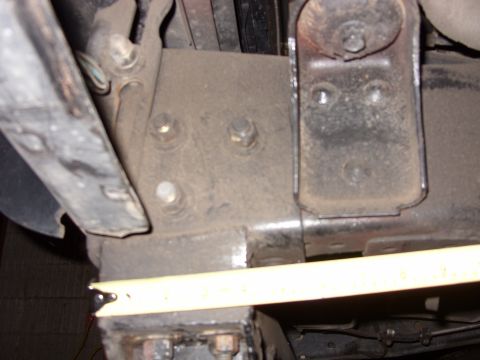 1988 Ford Bronco - Undercarriage view of a vehicle's frame and suspension components, with a tape measure indicating a measurement.