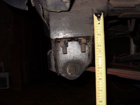 1988 Ford Bronco - A measuring tape is used to assess the size of a vehicle's suspension component.