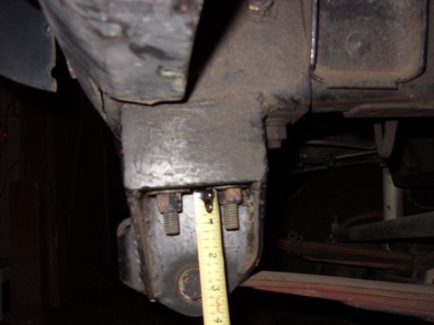 1988 Ford Bronco - A measuring tape is used to gauge the size of a suspension component, likely for modification or repair.