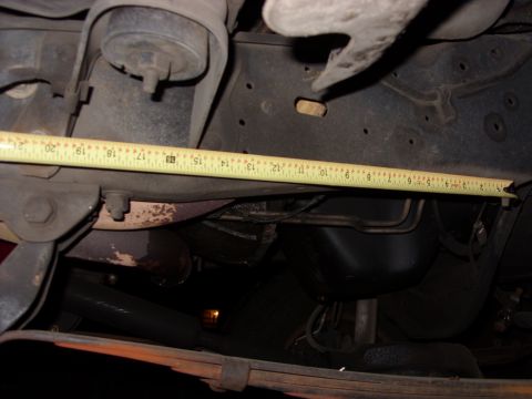 1988 Ford Bronco - Measuring vehicle frame components with a tape measure.