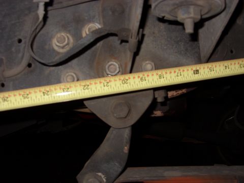 1988 Ford Bronco - A measuring tape is used to measure the distance between suspension components on a vehicle.
