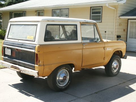 1966 Ford Bronco - This 1966 Ford Bronco is parked in front of a house, showing its side and rear profile.