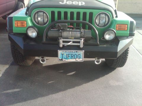1987 Suzuki Samurai - Front view of a green Jeep Wrangler equipped with a winch and aftermarket bumper.