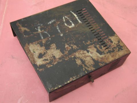 1991 Ford LTD Crown Victoria - A weathered black metal box, marked with 'B 8701', sits on a pink surface.