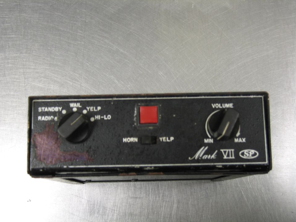 Black siren control unit with knobs for volume and function, and a red button