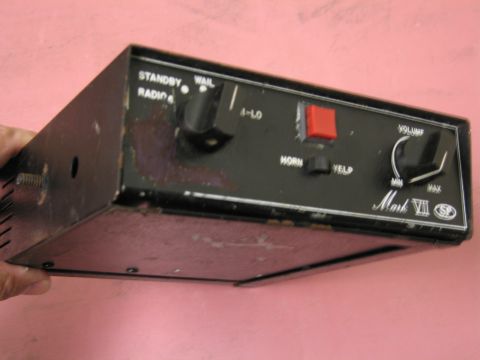 1991 Ford LTD Crown Victoria - A black audio control unit with various buttons and knobs is held by a hand.