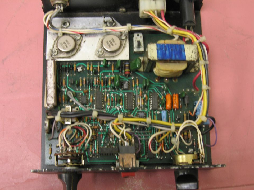 Internal view of an electronic circuit board with transistors, resistors, capacitors, and wiring