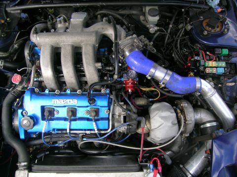 1995 Ford Probe - Close-up view of a modified engine bay, highlighting a turbocharger and custom piping.