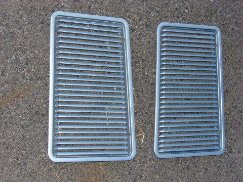 1993 Jeep YJ - Two silver vent grilles with horizontal slats are shown on a concrete surface.