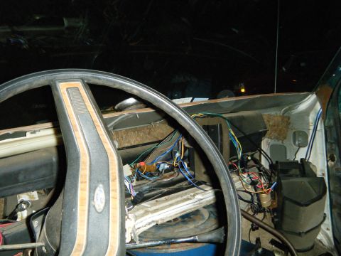 1981 Ford E350 - The interior of a 1981 Ford E350 shows exposed wiring and a wood-grain steering wheel, suggesting a repair or modification in progress.