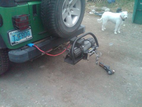 1987 Suzuki Samurai - A green Jeep's rear bumper is equipped with a winch and spare tire, a license plate that reads TJFROG.