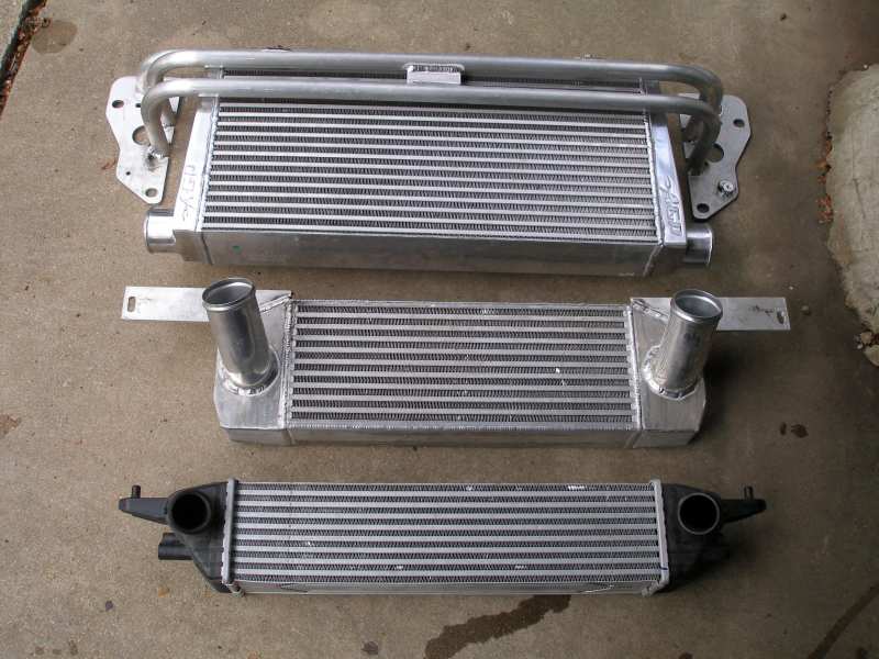 Three intercoolers of varying sizes laid out on a concrete surface