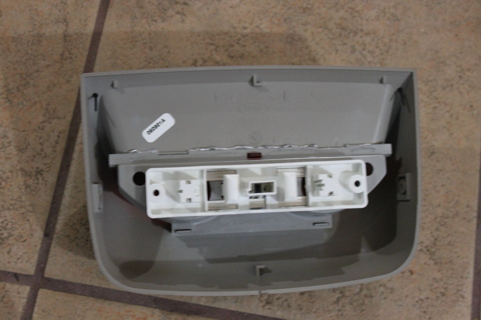 Underside of a gray plastic overhead dome light housing