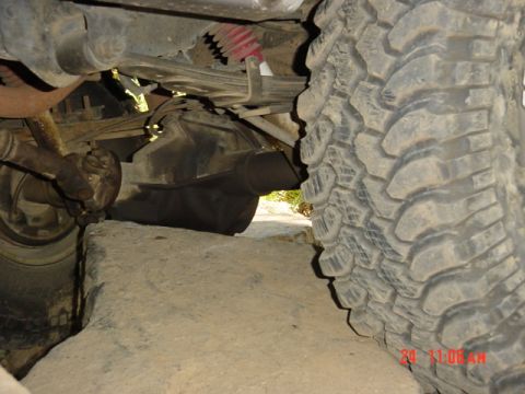 1989 Ford Bronco - A close-up view of a vehicle's undercarriage, highlighting its off-road tires and suspension system.