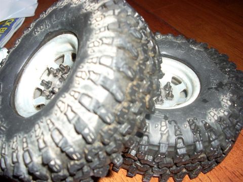 1994 Ford Escort - Close-up view of two off-road tires and their white rims, showing aggressive tread patterns.
