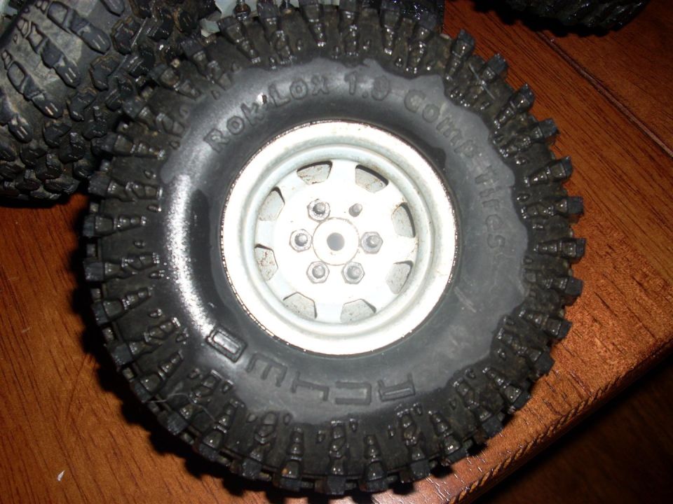 Close-up of an off-road tire with aggressive tread and 'ROKLOX 1.9 Comp Tires' text
