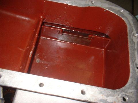 1965 Shelby Cobra - Close-up of an engine's oil pan interior, showing a red coating and a metal baffle.
