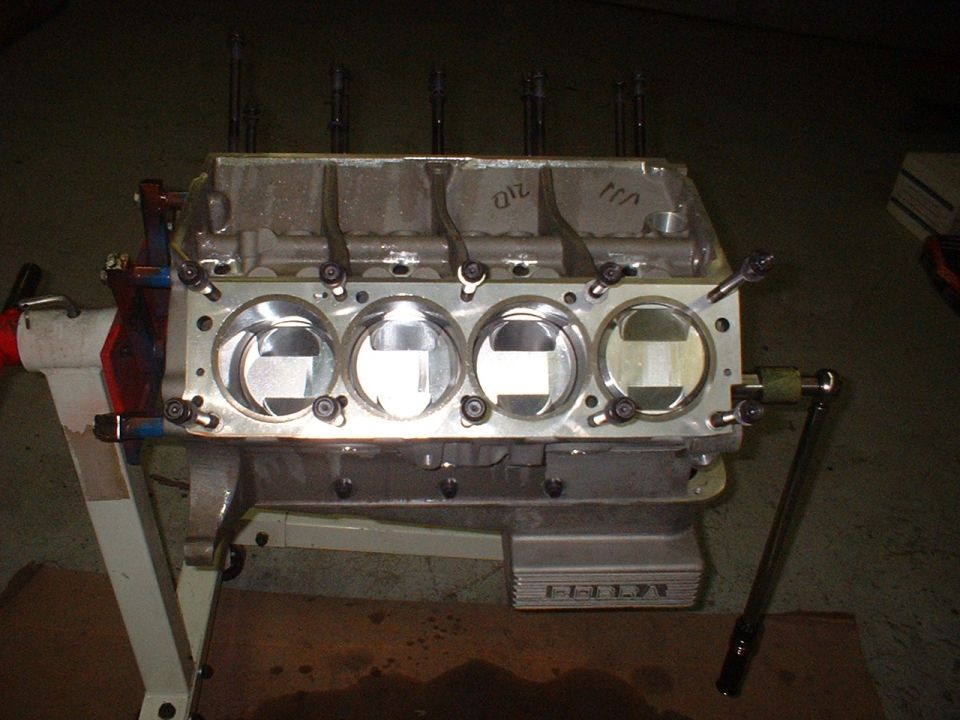 Engine block on stand, showing pistons and cylinder bores. Some writing on the top