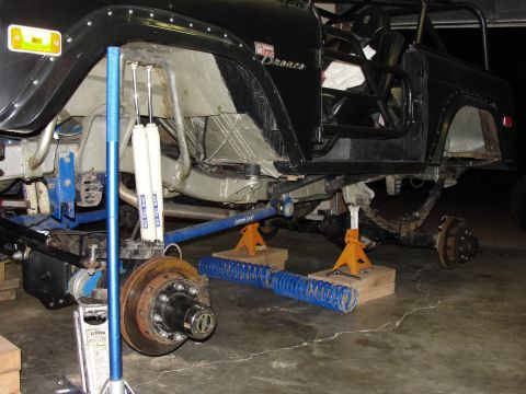1967 Ford Mustang - Ford Bronco undergoing suspension work, showing disassembled front end and shock absorbers.