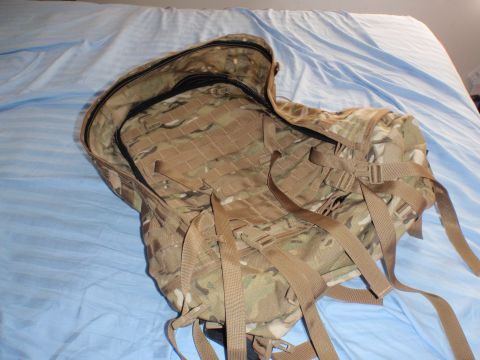 1991 Ford Bronco - A camouflage backpack with multiple straps and buckles is shown open on a bed.