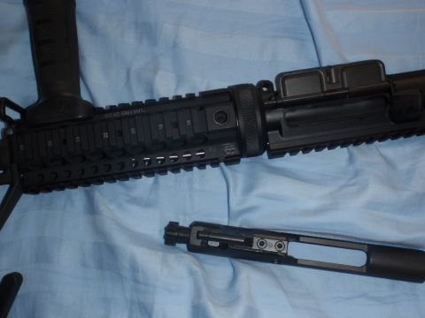 1991 Ford Bronco - Close-up view of an AR-15 rifle's upper receiver assembly and bolt carrier group, disassembled.