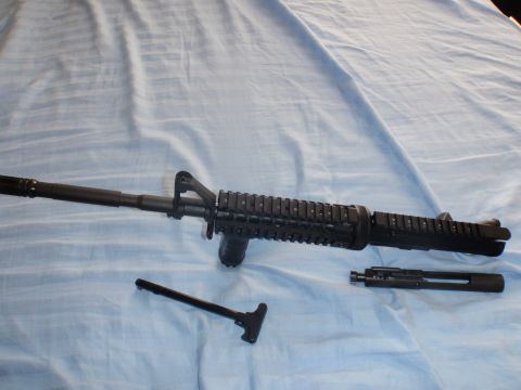 1991 Ford Bronco - AR-15 upper receiver, charging handle, and bolt carrier group are displayed on a blue fabric surface.