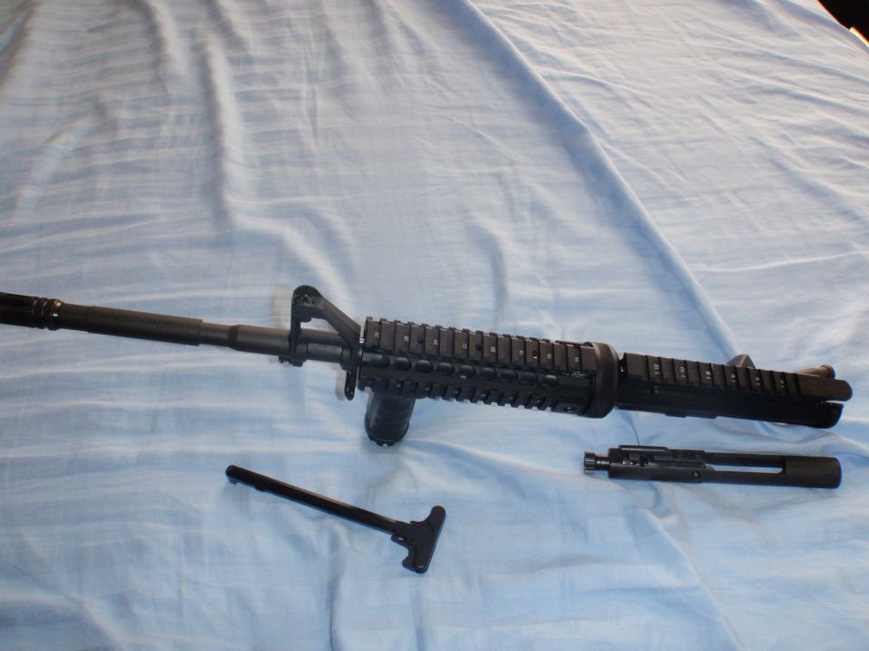 AR-15 upper receiver, charging handle, and bolt carrier group laid out on a blue cloth