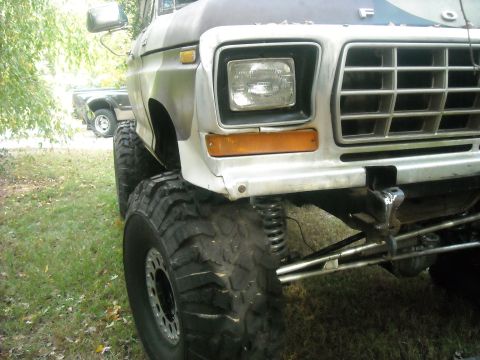 1979 Ford F-150 - Front quarter view of a lifted 1979 Ford F-150 pickup truck with oversized tires and custom suspension components visible.